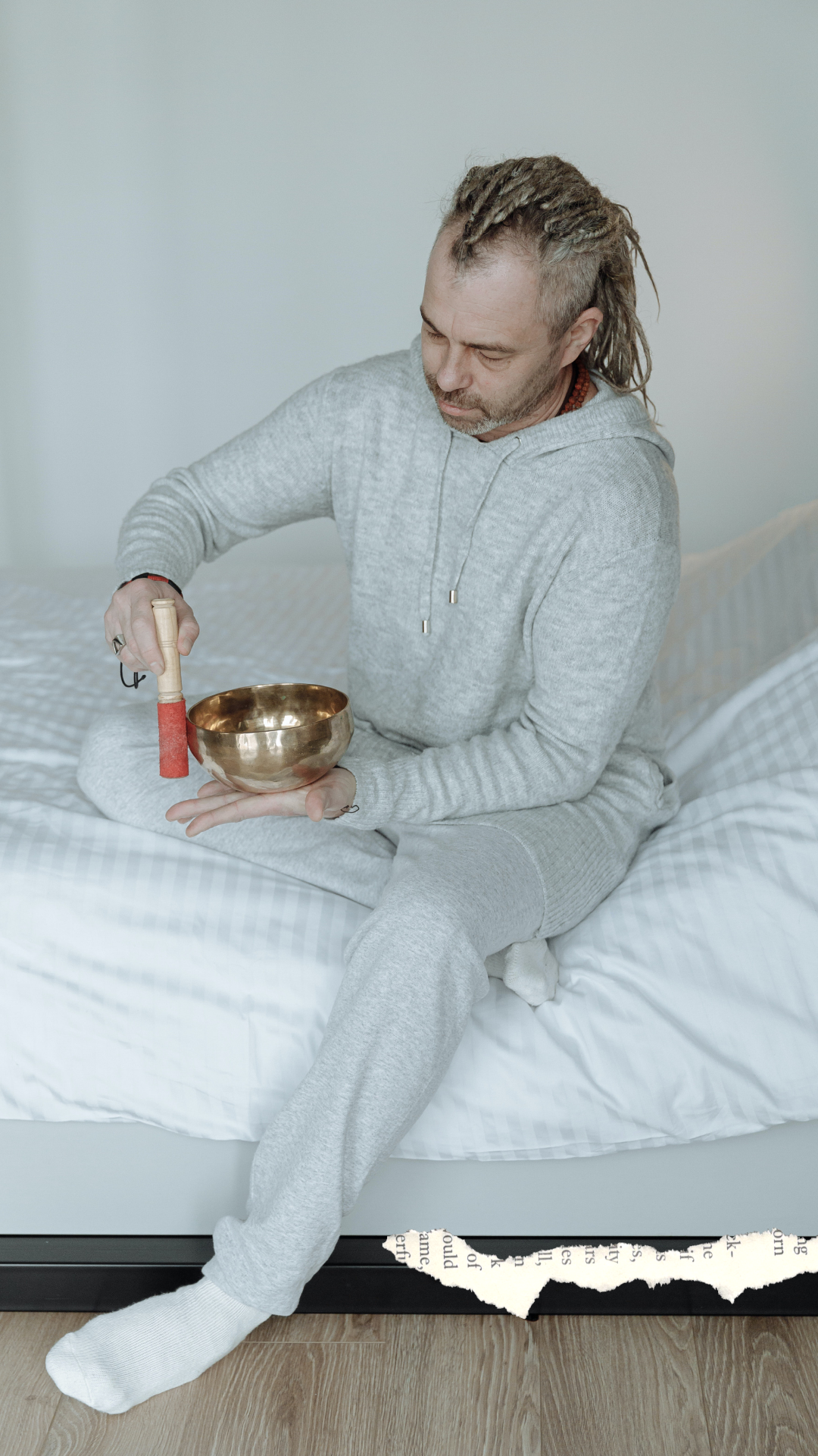 Man in his Pajamas playing singing bowl in bed