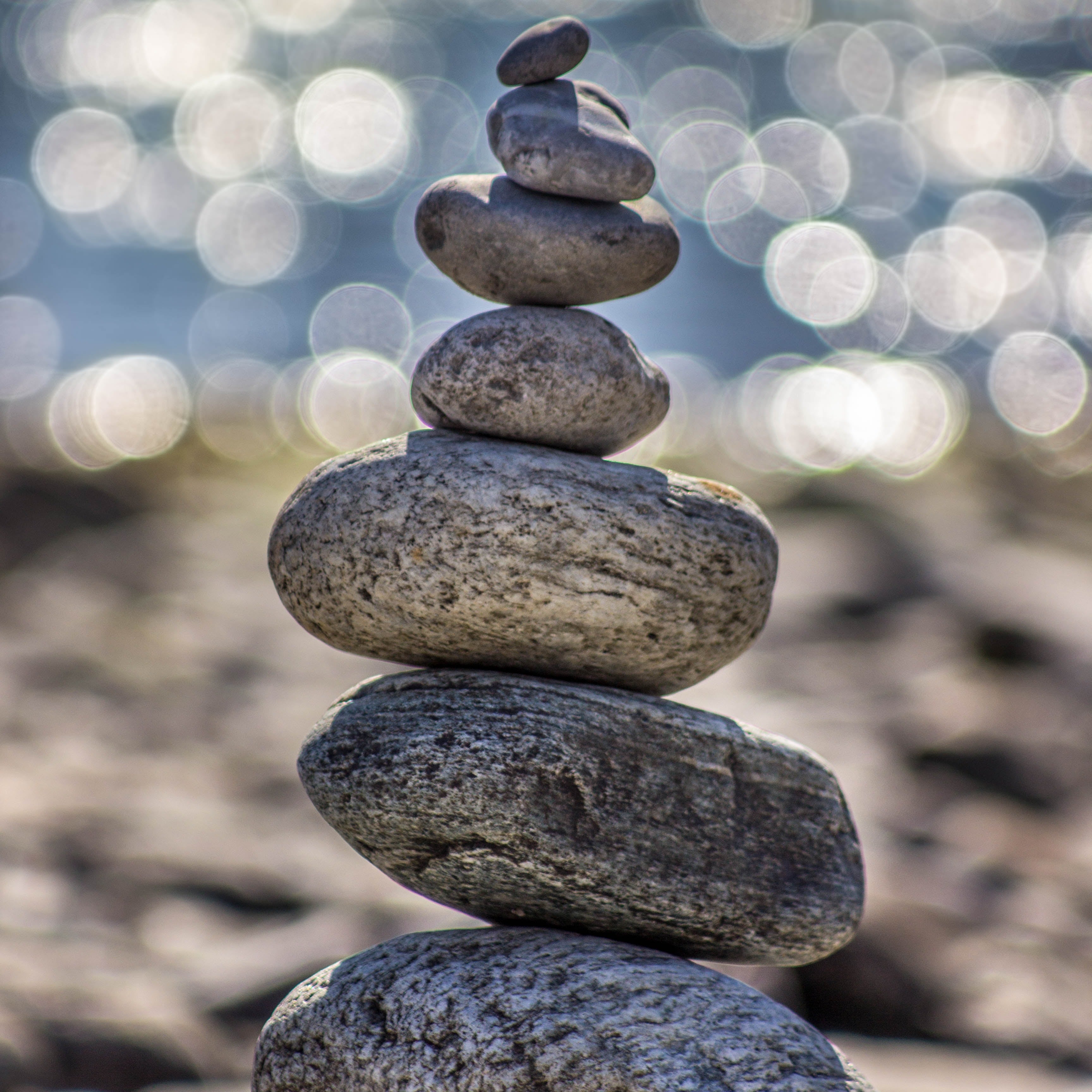 A stack of rocks are balanced atop one another, from the largest on the ground to the pebble at the top of the stack. 