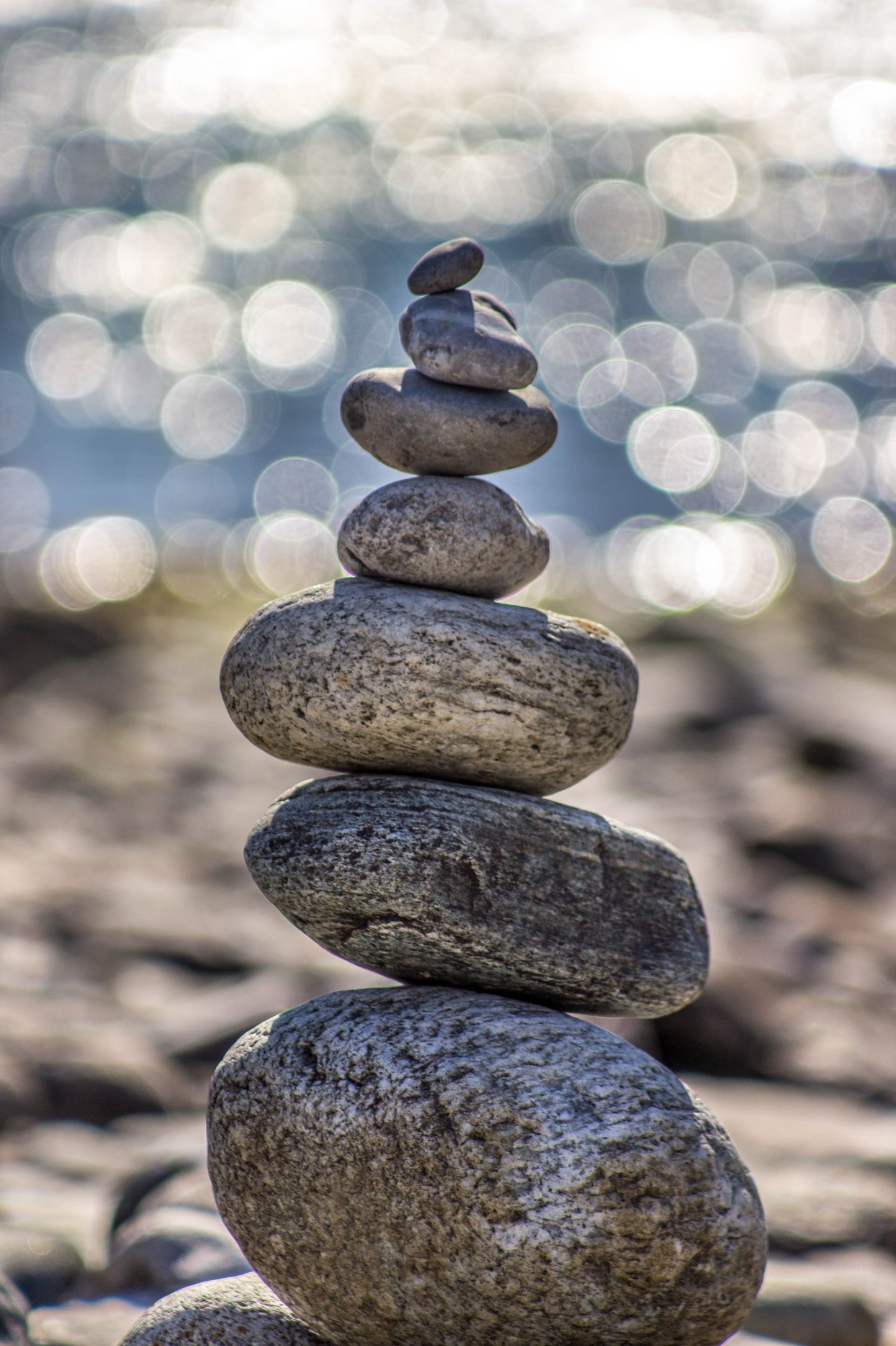 A stack of rocks are balanced atop one another, from the largest on the ground to the pebble at the top of the stack. 