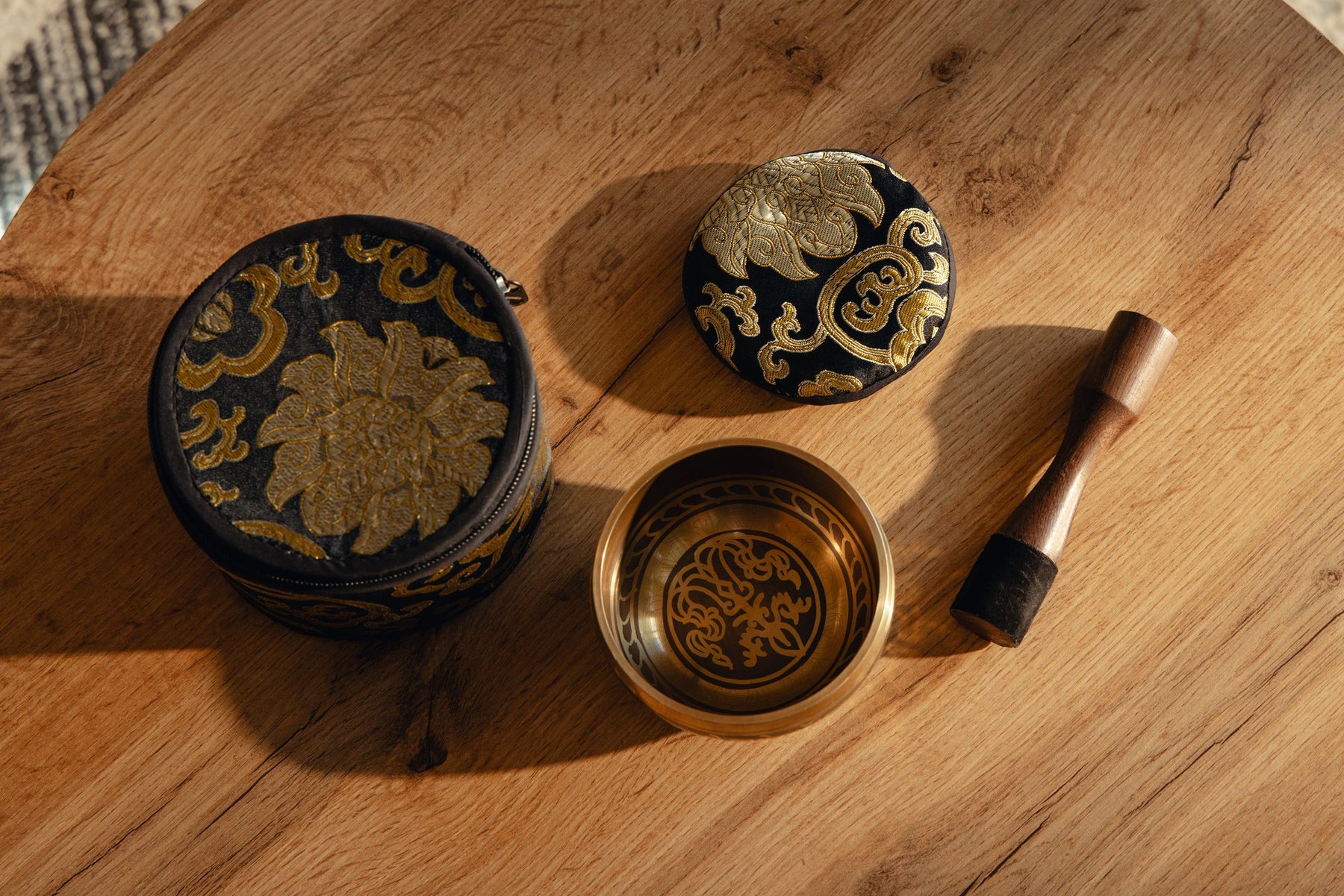 A cloth beside a Silent Mind singing bowl, cushion and wooden striker
