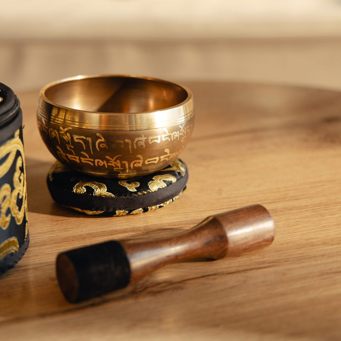 A singing bowl on its cushion, with its striker lying in front of it
